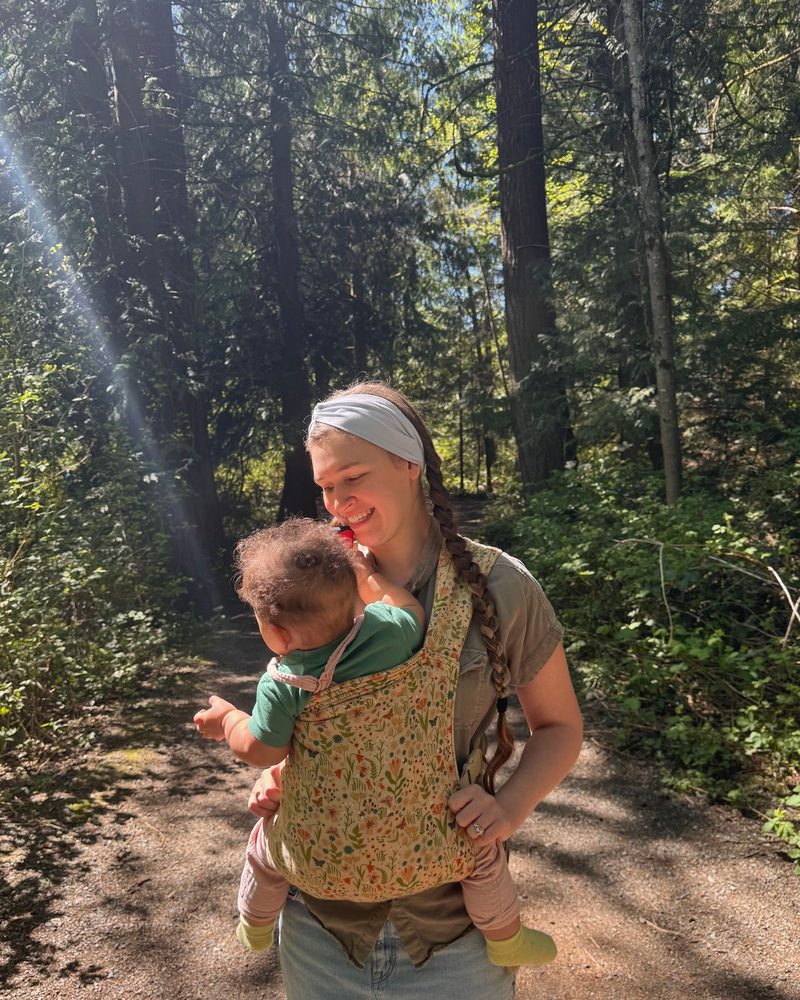 Mattison wearing her daughter in her hope&plum Lark carrier, ready for a forest school morning