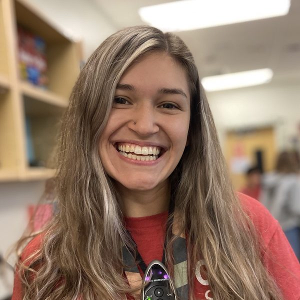 Mattison smiling in a classroom, wearing a red T-shirt
